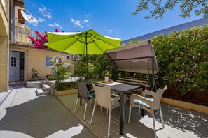 An outdoor patio with a table and chairs, a green umbrella, and potted plants. - Zadar Studio Klaric 2 /w Garden, Zadar, Croatia (Zadar)