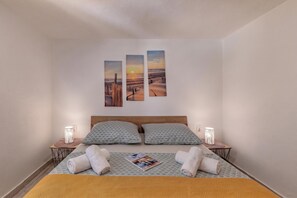 A bedroom with a bed, two bedside lamps, and three wall-mounted paintings. - Zadar App Klaric 1 with Garden, Zadar, Croatia (Zadar)