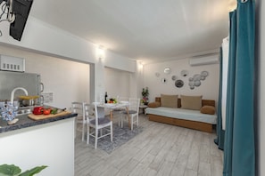 A compact living space with a kitchenette, dining area, and a sofa. - Zadar App Klaric 1 with Garden, Zadar, Croatia (Zadar)