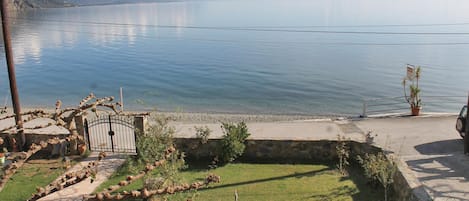 Una propiedad junto al lago con un sendero pavimentado, un muro de piedra y vistas al lago.