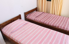 Two single beds with wooden frames and striped bedding.