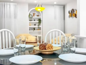 Uma mesa de jantar com pratos, copos e um arranjo central.