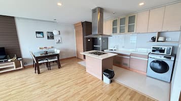 A modern kitchen with a central island, built-in appliances, and a dining area with a table and chairs.
