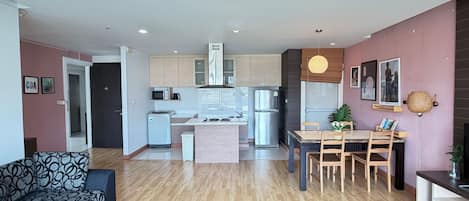 A modern apartment with a living room, dining area, and kitchen.
