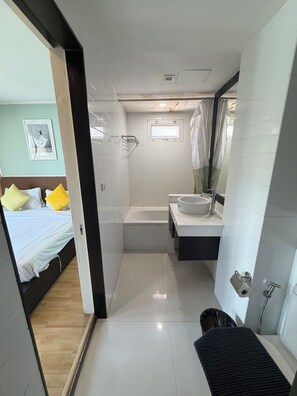 A modern bathroom with a bathtub, sink, and mirror. - P Residence Thonglor  (Bangkok)