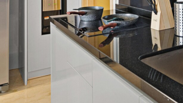 A kitchen with a stainless steel sink, a stove, and various cooking utensils. - Cavren by Kozystay - MERR (Surabaya)