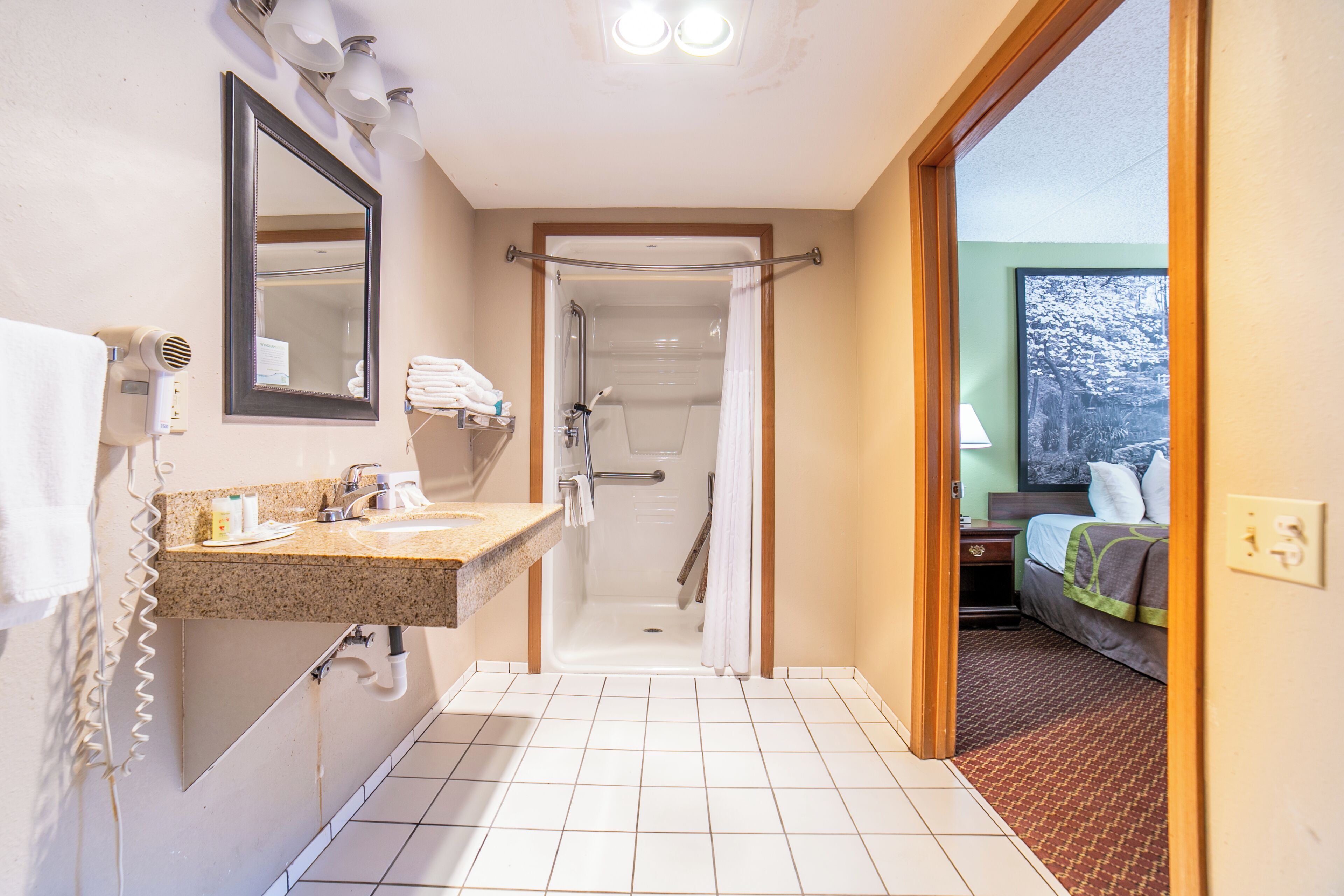 A bathroom with a shower, a sink, and a mirror.