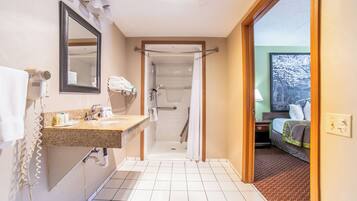 A bathroom with a shower, a sink, and a mirror.