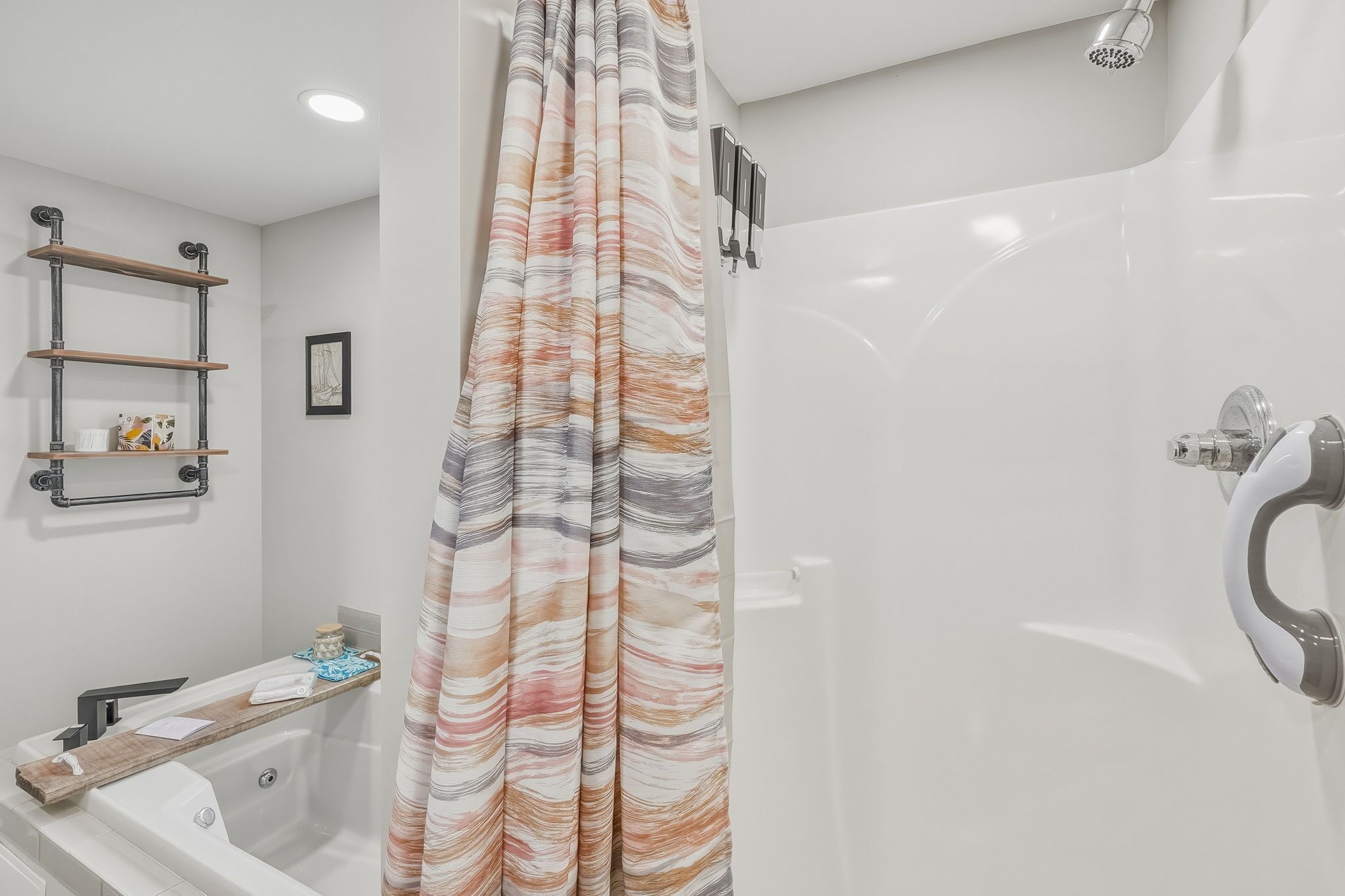 A modern bathroom with a shower, a bathtub, and a toilet. There are shelves on the wall and a framed picture.