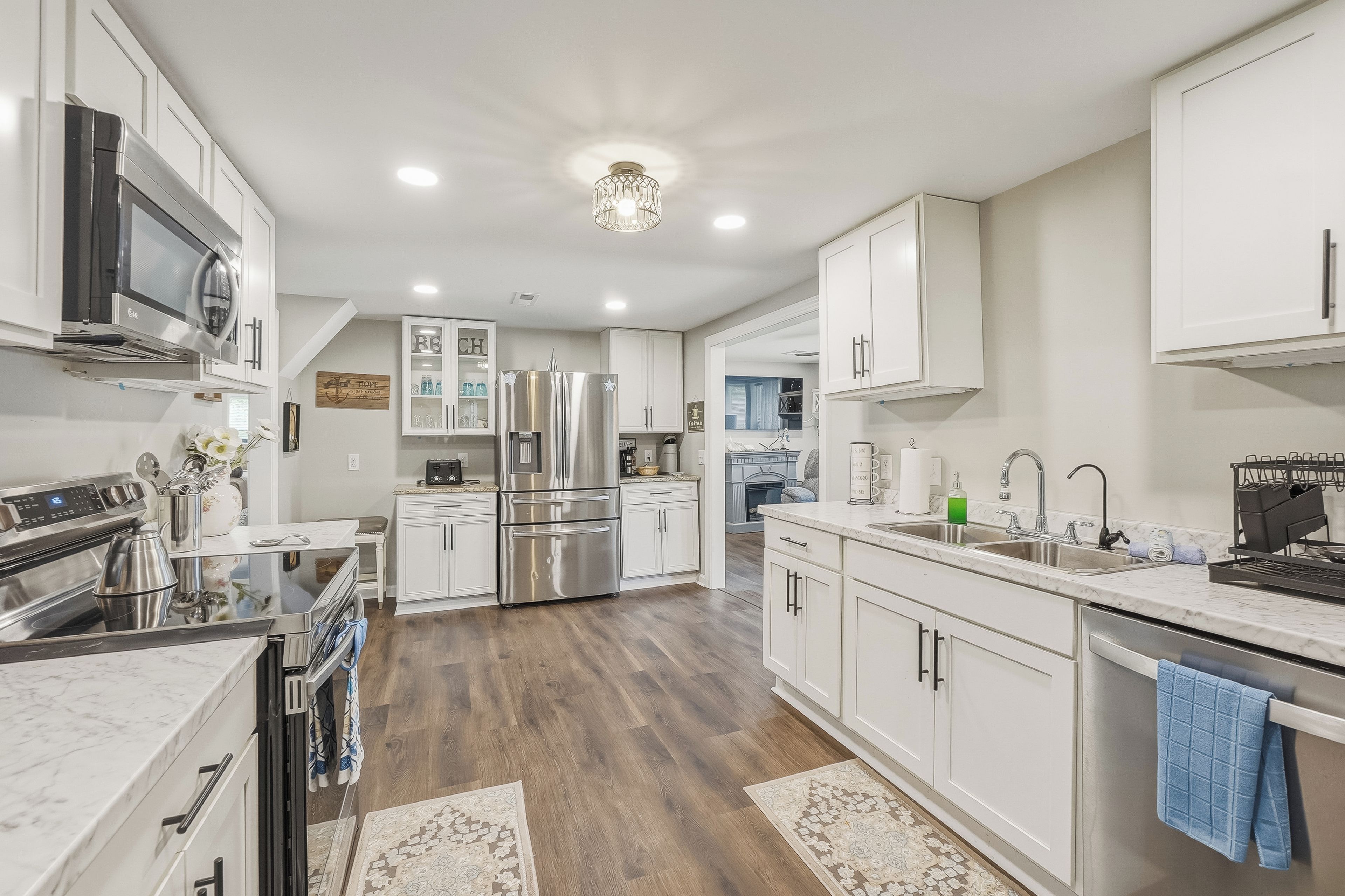 A modern kitchen with stainless steel appliances, white cabinetry, and a central island.