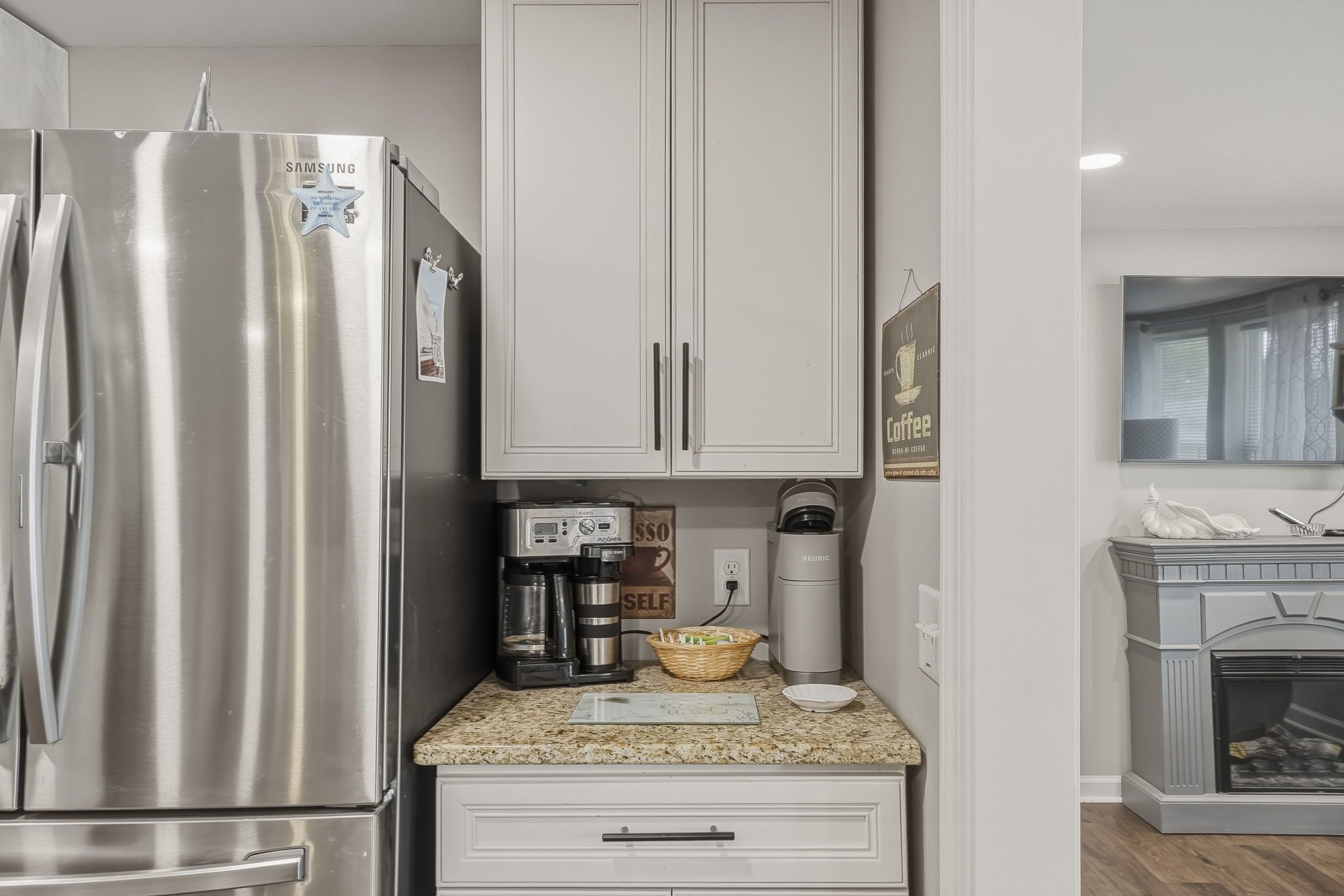 A modern kitchen with a stainless steel refrigerator, a coffee maker, and a microwave.