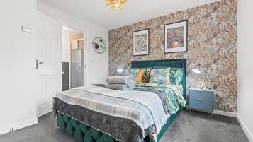 A bedroom with a bed, a nightstand, a wall clock, and a door.