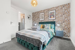 A bedroom with a bed, a nightstand, a wall clock, and a door. - #16 Stunning 3 Bed home|near Core Theatre|Sleep 7 (West Midlands)