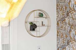 Una pared con un estante circular que contiene adornos.