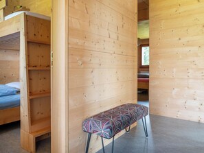 A wooden interior with a bench, a bed, and a built-in wardrobe. - Labbrunnu OG 5-Bettwohnung, Dusche, WC 5-Bettwohnung, Dusche, WC by Interhome (Rosswald)