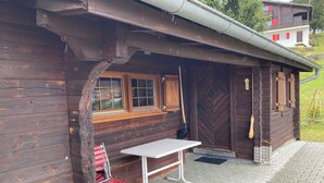 A wooden cabin with a bench and a table outside. - Chalet Glimuschir Appartement/Fewo, Dusche, WC Appartement/Fewo, Dusche, WC by Interhome (Rosswald)