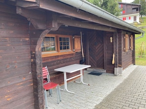A wooden cabin with a bench and a table outside. - Chalet Glimuschir Appartement/Fewo, Dusche, WC Appartement/Fewo, Dusche, WC by Interhome (Rosswald)