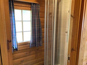 Puinen sisustus, jossa on ikkuna ja suihkutila.