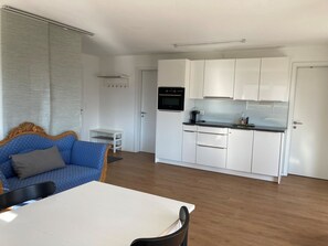 Een ruimtelijk ingedeeld verblijf met kitchenette, eethoek en zithoek.