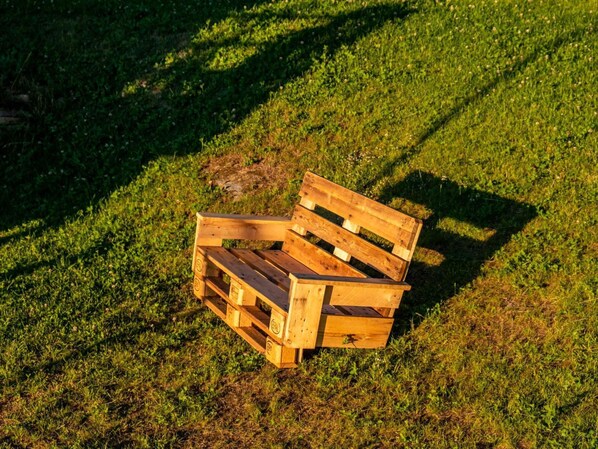 A wooden bench on a grassy field.