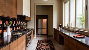 Una cocina moderna con una isla central, electrodomésticos de acero inoxidable y vistas al área de estar contigua.