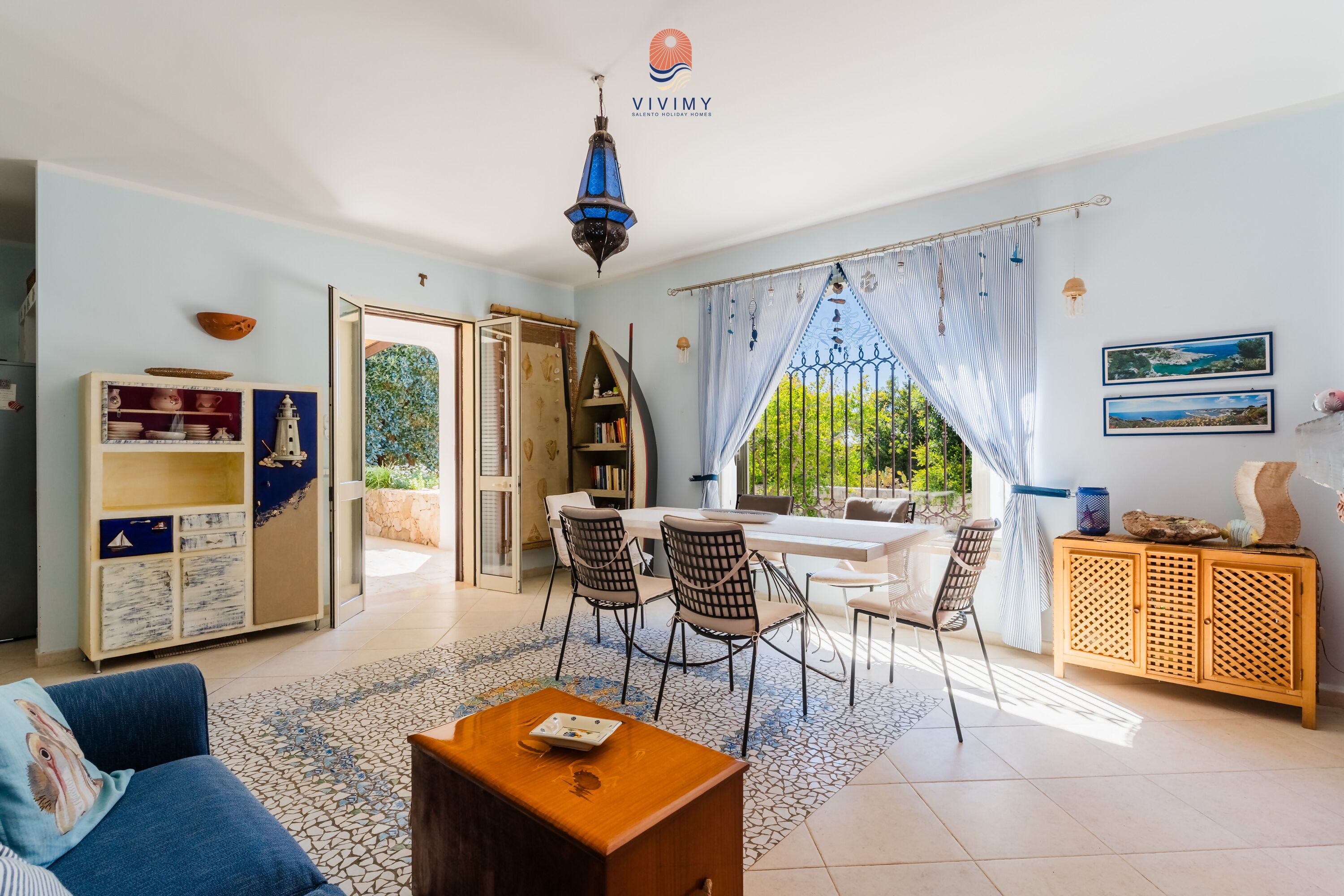 Uma sala de estar espaçosa com área de jantar, uma estante de livros e vista para o exterior.