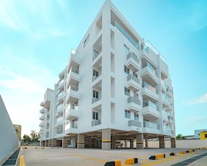 Un immeuble moderne à plusieurs étages, doté d’un toit plat, de grandes fenêtres et de balcons.
