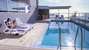 A poolside area with lounge chairs, a pool, and a view of the sea. - Hotel Costa del Sur (Ilo)