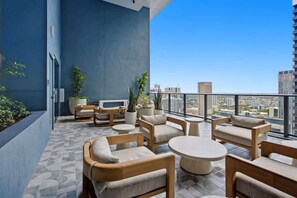 A modern balcony with seating, potted plants, and a city view. - Modern Downtown Stay | Premium Resort Amenities (Miami)
