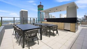 Une terrasse sur le toit comprenant un espace repas, un bar et offrant une vue sur le panorama urbain.