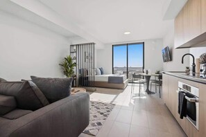 A modern apartment with a living area, kitchenette, and a balcony with a city view. - Modern Downtown Stay | Premium Resort Amenities (Miami)