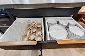 A drawer with kitchenware, including plates and cups.