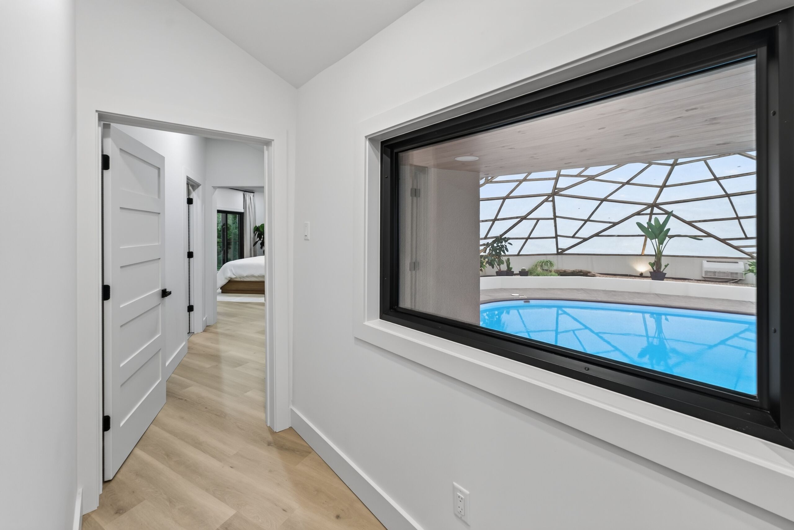 Un interior moderno con un ventanal grande que da a una piscina.