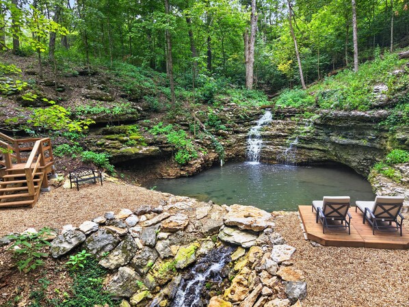 Un cadre naturel agrémenté d’une cascade, d’une terrasse en bois et d’un espace détente.