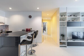 Una cocina moderna con una isla central, taburetes de bar y un comedor.