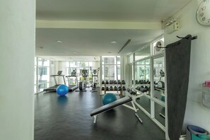 A gym with treadmills, exercise balls, and weight racks. - The Regent Kamala Condominium by PSR (Tambon Kamala)