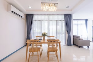 Un comedor moderno con una mesa de madera, sillas y una lámpara de araña.