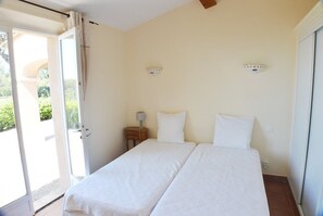 Une chambre avec deux lits, une table de chevet et une fenêtre avec des rideaux.