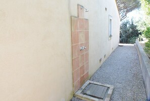 A narrow outdoor pathway leading to a tiled shower area with a small window. - Belle Villa 4 chambres à Gigaro avec vue mer (LA CROIX VALMER)