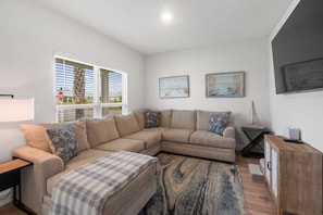A modern living room with a sectional sofa, a coffee table, and a wooden cabinet. - Windmark Coastal Paradise 5BR/5BA, private Pool, sleeps 18, pet friendly, 2 golf carts (Port St. Joe)