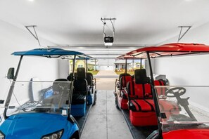 A garage with two golf carts parked side by side. - Windmark Coastal Paradise 5BR/5BA, private Pool, sleeps 18, pet friendly, 2 golf carts (Port St. Joe)