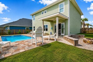 A residential property with a swimming pool, patio furniture, and a well-maintained lawn. - Windmark Coastal Paradise 5BR/5BA, private Pool, sleeps 18, pet friendly, 2 golf carts (Port St. Joe)