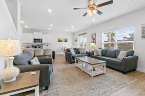 A spacious living area with a sofa set, a coffee table, and a dining area with chairs. - Windmark Coastal Paradise 5BR/5BA, private Pool, sleeps 18, pet friendly, 2 golf carts (Port St. Joe)