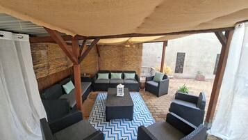 An outdoor seating area with wicker furniture and a patterned rug.