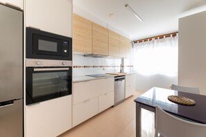 A modern kitchen with a built-in oven, microwave, and dishwasher. - Volvoreta Valdoviño Apartment (Valdoviño)