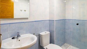 Kylpyhuone, jossa on valkoinen pesuallas, wc ja suihku.