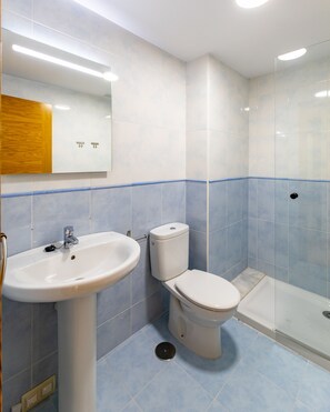 A bathroom with a white sink, toilet, and shower. - Volvoreta Valdoviño Apartment (Valdoviño)