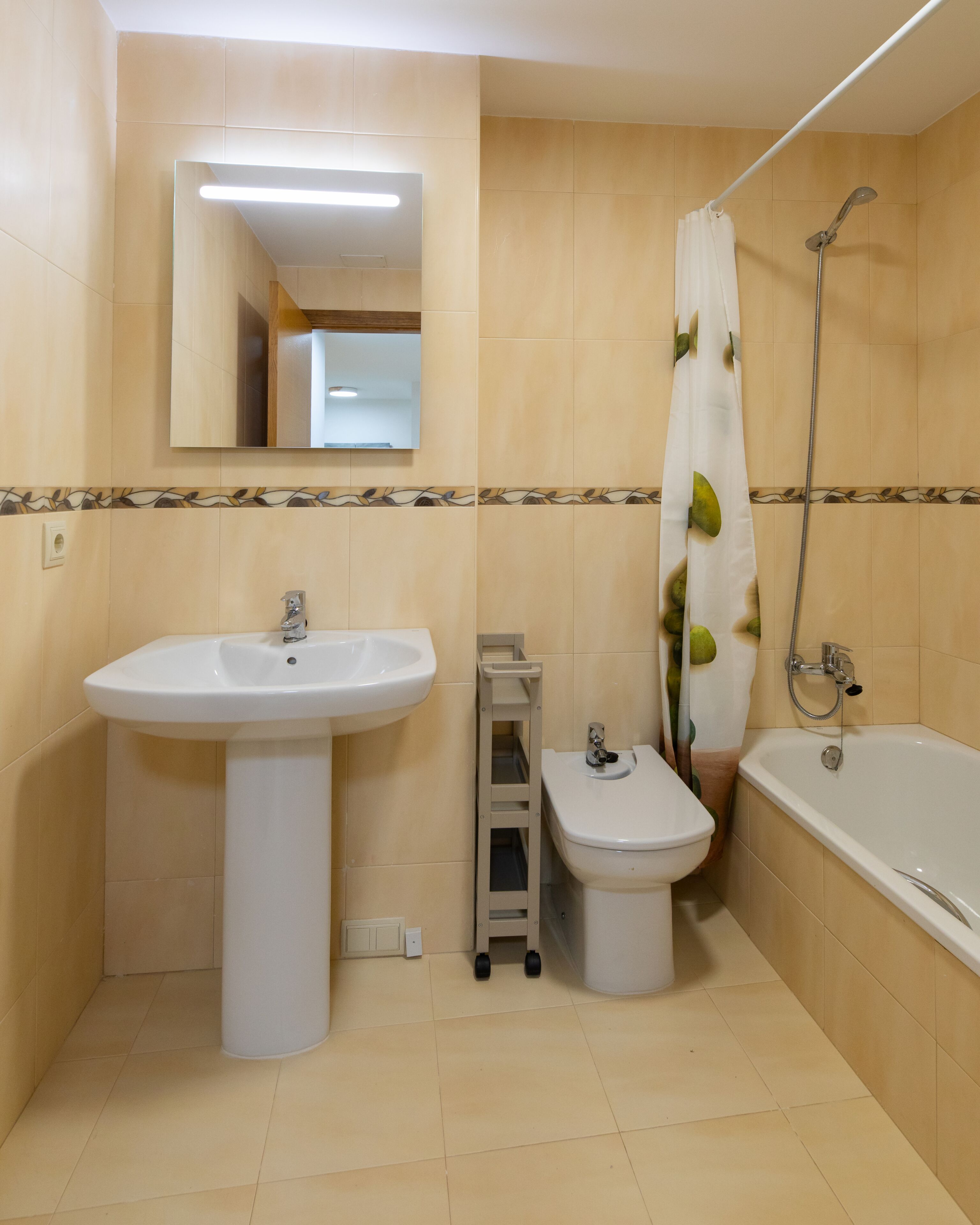 A bathroom with a sink, bidet, and bathtub.