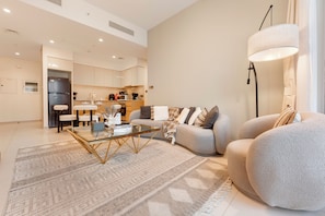 A modern living room with a glass coffee table, a sofa, and a floor lamp. - Walk to Dubai Mall and Dubai Fountain Parking Pool (Dubai)