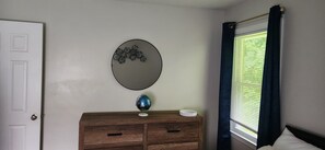 Ein Schlafzimmer mit einem Holzkoffer, einem Globus und einem Wandspiegel.